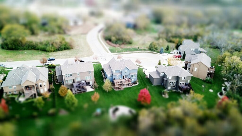 pexels-photo-667221-667221 Aerial photo showcasing residential houses in a suburban neighborhood with lush greenery and streets.